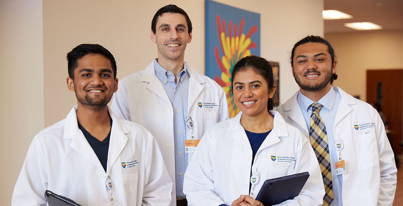 four smiling medical students standing in the hallway at Rowan-Virtua SOM