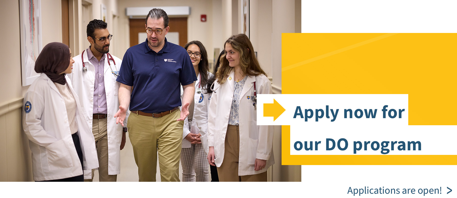 Apply now for our DO program. Medical students walk in a hallway with Dr. Brolis
