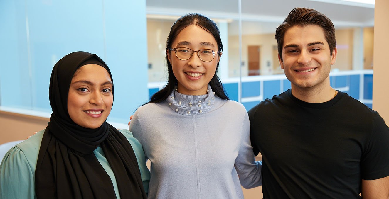 Three smiling SOM students at the Sewell campus