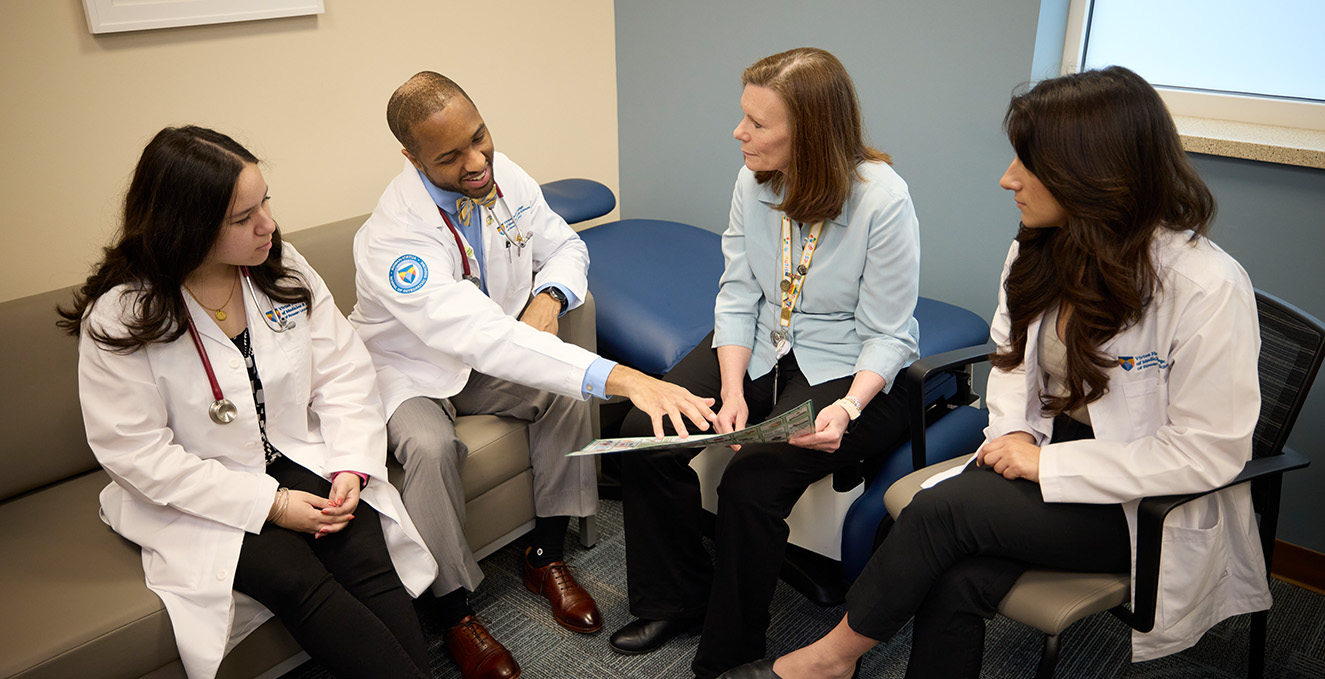 a group of Rowan-Virtua SOM students discuss information with a doctor from RISN