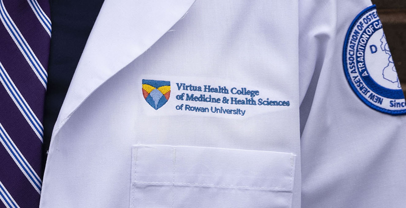 Picture of the VHC logo on a white coat of a doctor wearing a blue striped tie