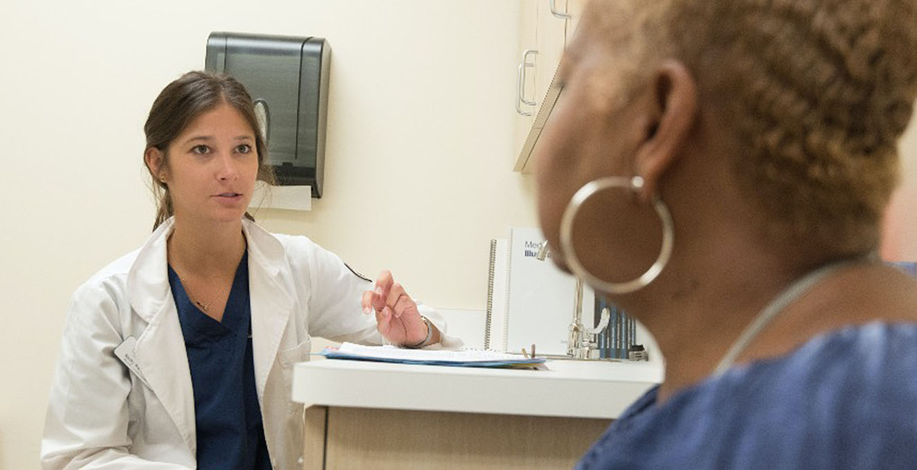 student works with a standardized patient in a clinical setting