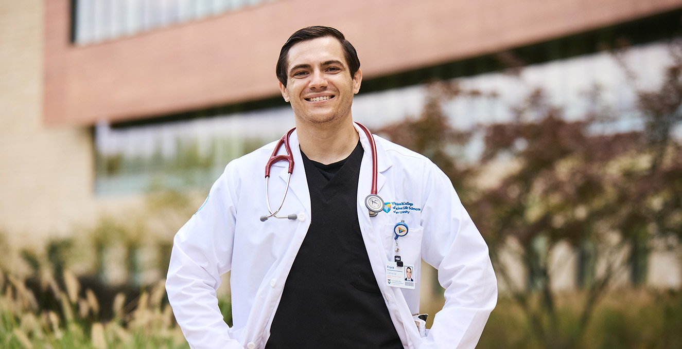 An SOM student smiles while standing outside the Virtua Voorhees hospital