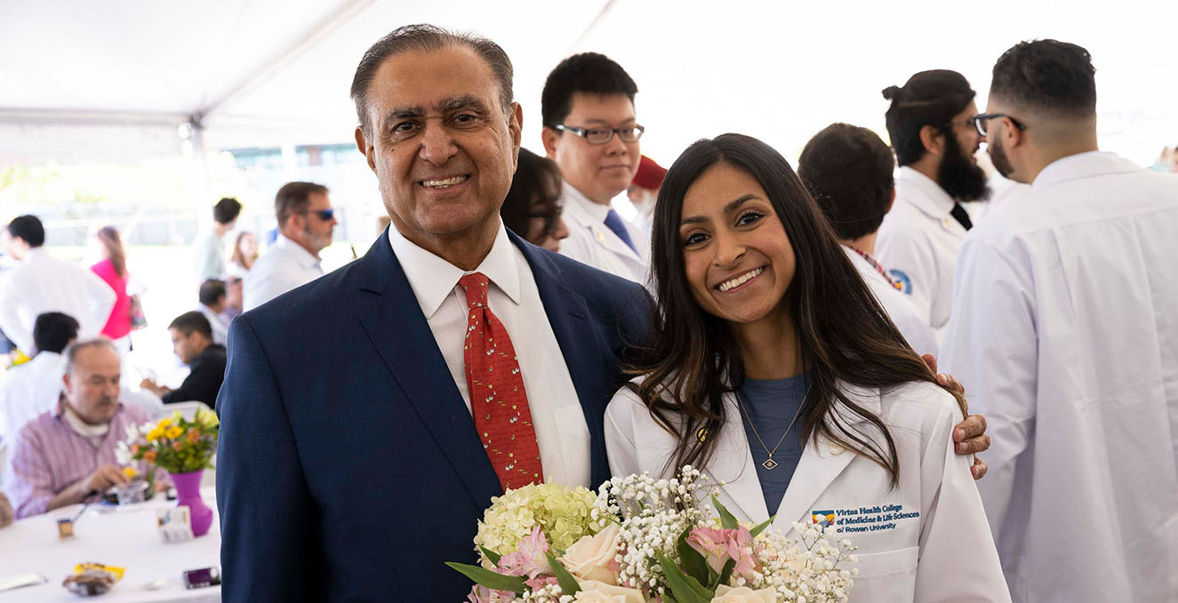 a father hugs his daughter at the Rowan-Virtua SOM white coat ceremony