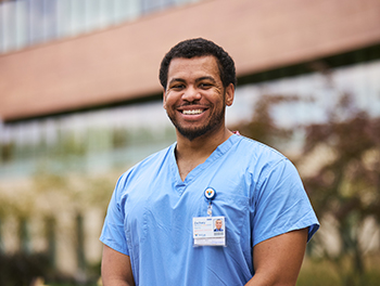 a Rowan-Virtua SOM student smiles at the camera while standing outside Virtua Voorhees hospital