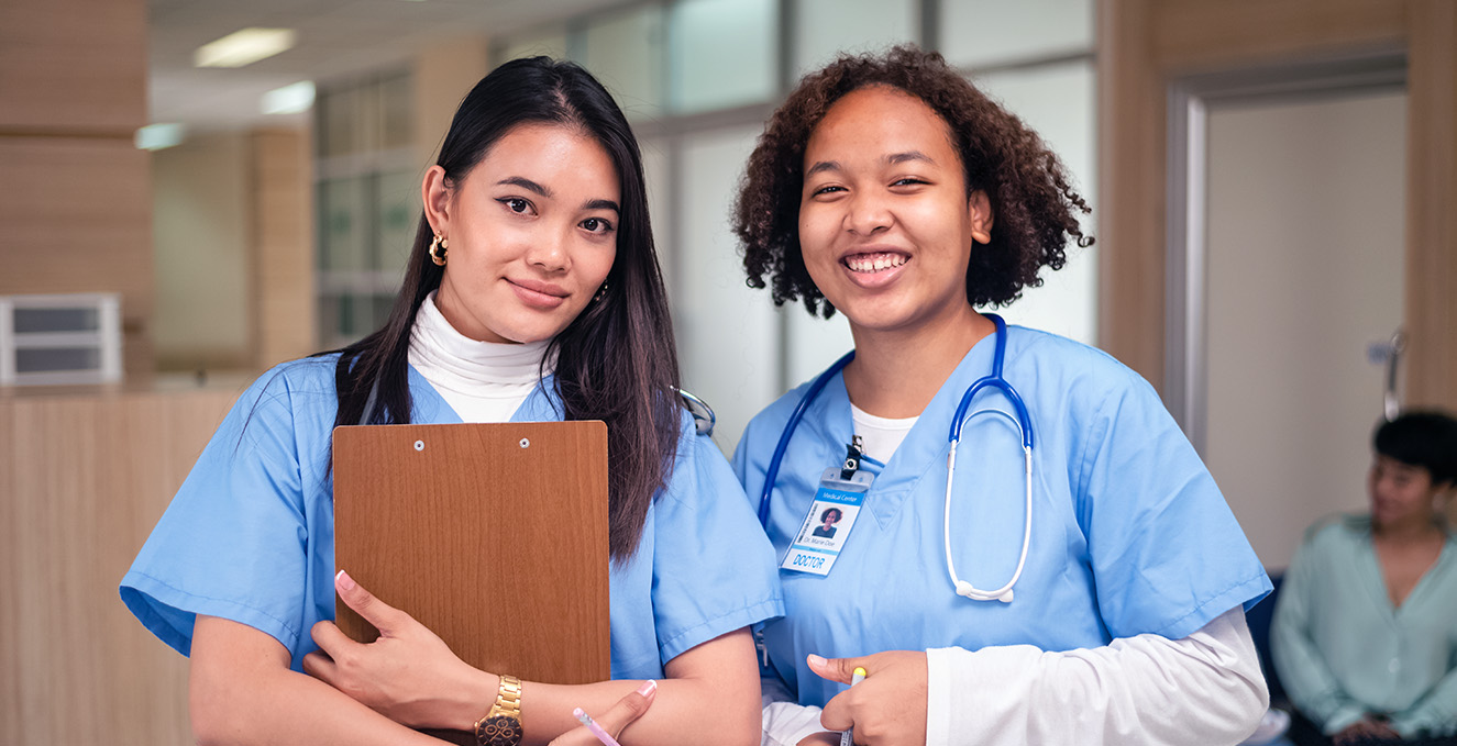 two health care students smile in the hallway