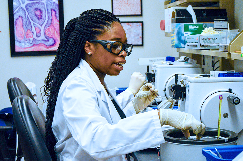 researcher working at a microscope in the lab