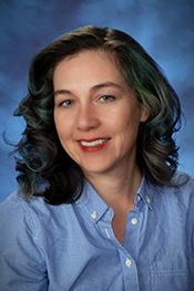Jennifer Fischer wears a blue button-down shirt and smiles at the camera