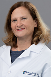 Tanya Kadrmas-Iannuzzi smiles at the camera while wearing a dark shirt and whitecoat