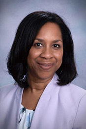Paula Watkins wear a blue blouse and smiles at the camera