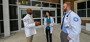 medical students standing in front of Sewell campus doors